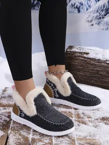 Women's warm winter boots with cream faux fur lining and charcoal felt upper on snow