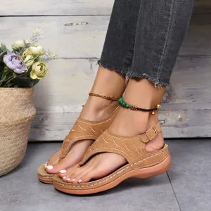 Detailansicht der braunen bestickten Zehenstegsandalen mit Keilsohle und Schnalle.