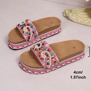 Detalle de sandalias de plataforma con cuentas de colores y suela de corcho de 4 cm.