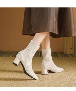 Gedetailleerde weergave van beige gebreide enkellaarzen met blokhak en een textuur
