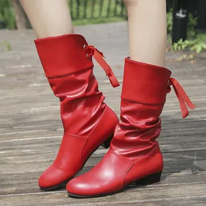 Primer plano de botas rojas arrugadas con lazo trasero y diseño plisado.