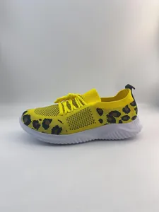 Side view of yellow fly-knit walking shoes with leopard print pattern and white sole.