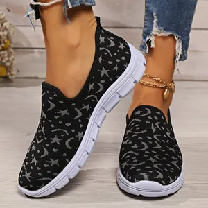 Primer plano de zapatillas de malla negra con diseño de luna y estrellas