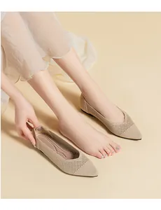 Close-up of beige knitted pointed-toe flat shoes showing breathable mesh texture detail.