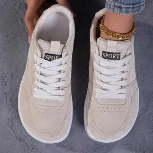 Vue de dessus de chaussures rétro à bout large crème sur un fond texturé gris élégant