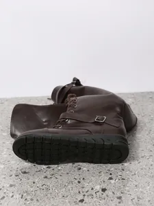 Detail view of stylish dark brown PU high boots showing the non-slip textured rubber sole