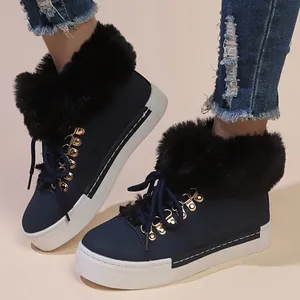 Close-up of navy blue winter snow boots with black faux fur collar and platform sole