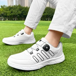 Detailed view of white men's golf shoes featuring a modern twist-knob lacing system on turf