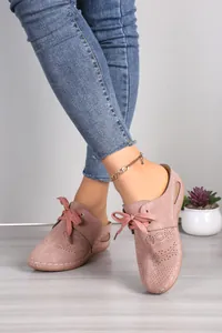 Close-up of pink lace-up hollow-out wedge mules on model feet with a gold anklet