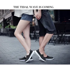 Close-up of black breathable woven slip-on shoes worn by a couple on a street