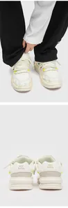 Detail view of retro white skate shoes with unique dreadlock rope laces and chunky soles.