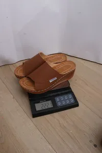Detailansicht des Gewichts einer braunen Keilpantolette auf einer Digitalwaage