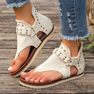 Detail view of off-white canvas thong sandals with rivets and back zipper closure