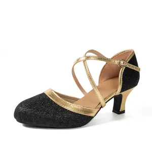 Detailansicht eleganter Tanzschuhe mit schwarzem Glitzer und goldenen Riemenbesatz.