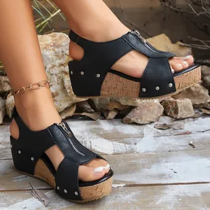 Detailed view of stylish black wedge sandals featuring a front zipper and silver rivets