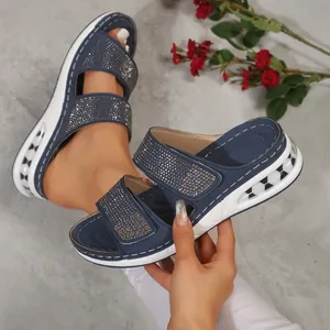 Close-up of navy blue wedge sandals featuring sparkling rhinestone embellishments
