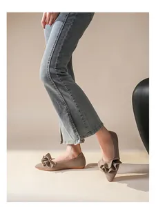 Seitenansicht von beigen spitzen Ballerinas mit Rüschendesign auf gewebtem Stoff