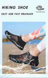 Detail view of black quick-dry wading shoes with water splash effect on a beach.