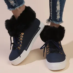 Close-up of navy blue women's snow boots with black faux fur trim and white sole.
