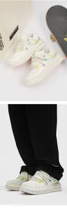 Detailed view of white retro skateboard shoes with thick rope laces and black trousers.