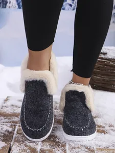 Close-up detail of women's warm winter house shoes with plush cream faux fur lining