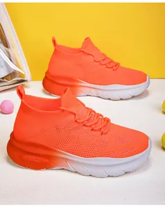 Detail of bright orange flyknit sock sneakers with thick white soles and slip-on design.
