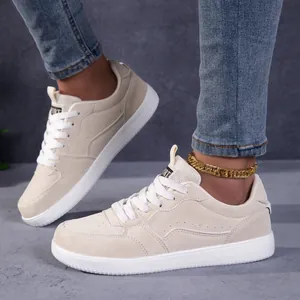 Vue détaillée de chaussures de skate rétro beiges avec une chaîne de cheville dorée