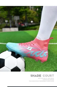 Action view of pink and blue soccer cleats on a green turf field with a soccer ball