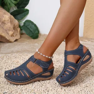 Detailed view of navy blue Roman wedge sandals with white stitching and cut-outs