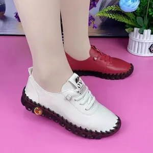 Detailopname van witte en rode comfortabele platte leren schoenen met zachte zolen