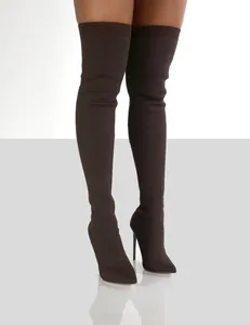 Detail view of brown knit thigh-high sock boots with pointed toe and stiletto heel.