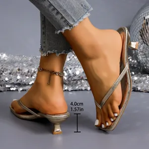 Close-up detail of 1.57 inch kitten heel on stylish metallic gold flip-flop sandals
