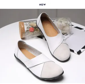 Detailansicht der weißen und grauen Leder-Loafer mit stilvoller Wildlederkappe