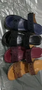 Detailed view of decorative flower and rhinestone embellishments on colorful wedge sandals