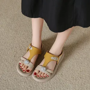 Stilvolle gelbe und beige Plateau-Sandalen mit Strasssteinen am Fuß Detailansicht