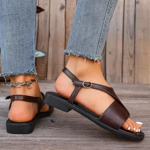Side detail of brown flat clip-toe sandals with an adjustable ankle strap and silver buckle