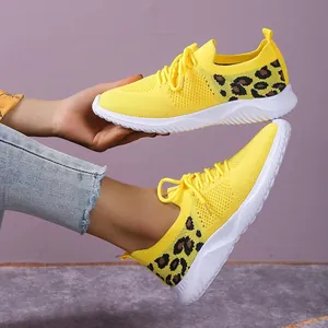 Close-up of yellow mesh sneakers featuring leopard print comfort detail and white soles.