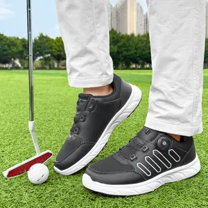 Close-up of men's black and white golf shoes with rotary buckle system on grass