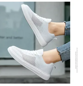 Close-up view of breathable white flyknit mesh sneakers with lightweight EVA sole
