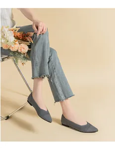 Elegant grey knitted pointed-toe flats worn by a model in a lifestyle setting