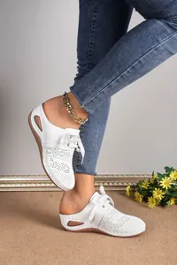 Side view of elegant white hollow-out lace-up mules featuring comfort wedge heels