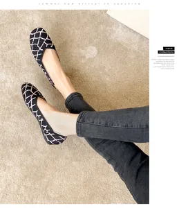 Close-up of square toe knit flats with pink geometric pattern on model