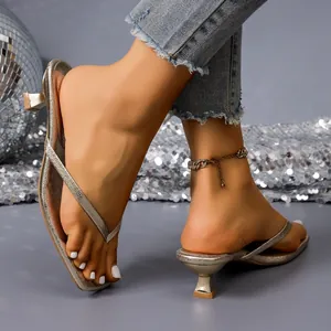 Close-up of stylish metallic low-heel thong sandals with square toe and kitten heel