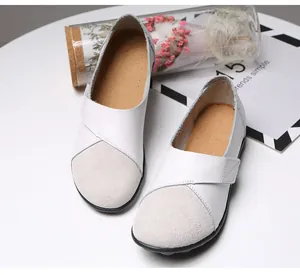 Nahaufnahme weißer Leder-Loafer mit grauer Wildlederkappe und Klettverschluss
