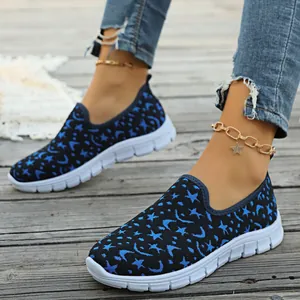 Primer plano de zapatillas de punto transpirable con estampado azul de estrellas y lunas.