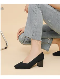 Detail view of black square-toe chunky heel pump with ribbed texture on model