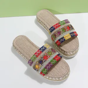 Close-up detail of colorful ethnic woven strap on women's platform rope slippers