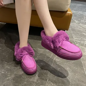 Détail des bottes d'hiver mauves avec doublure en fausse fourrure et nœud mignon