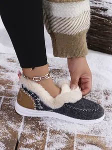 Close-up of women's warm grey winter slippers with thick white faux fur lining and tan heel
