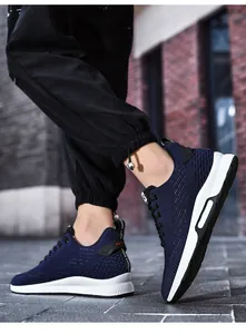 Close-up detail of navy blue breathable knit running shoes with supportive white soles